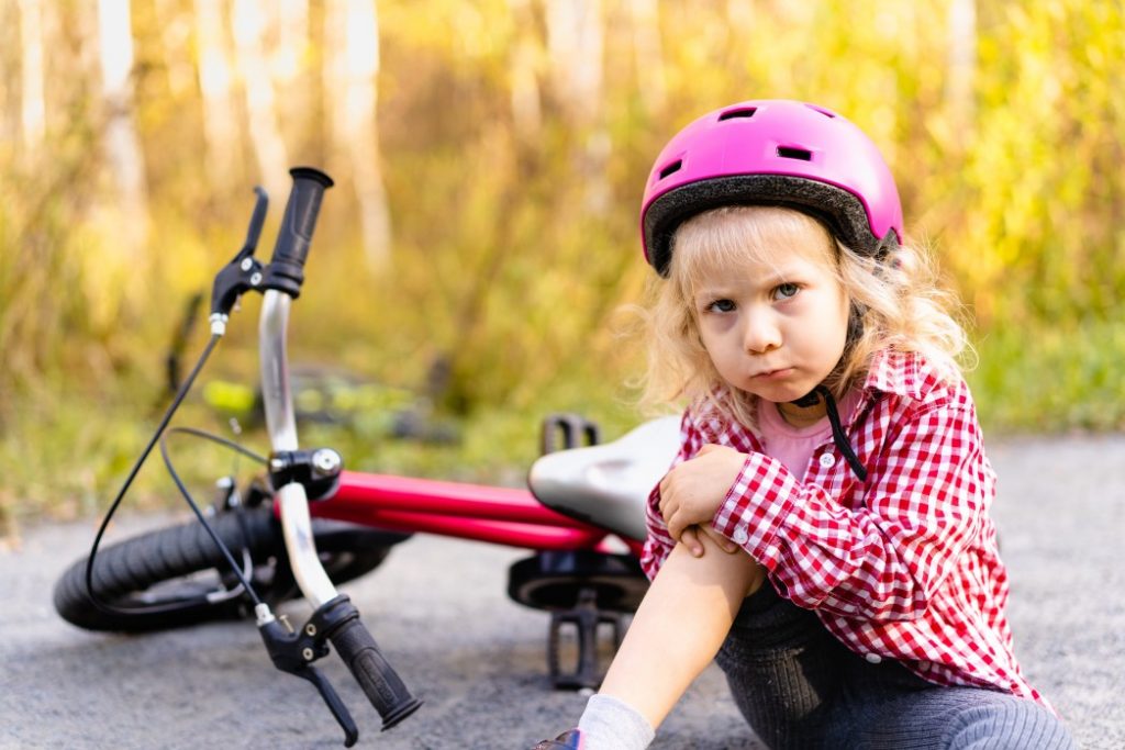 Kind nach einem Sturz beim Fahrradfahren lernen